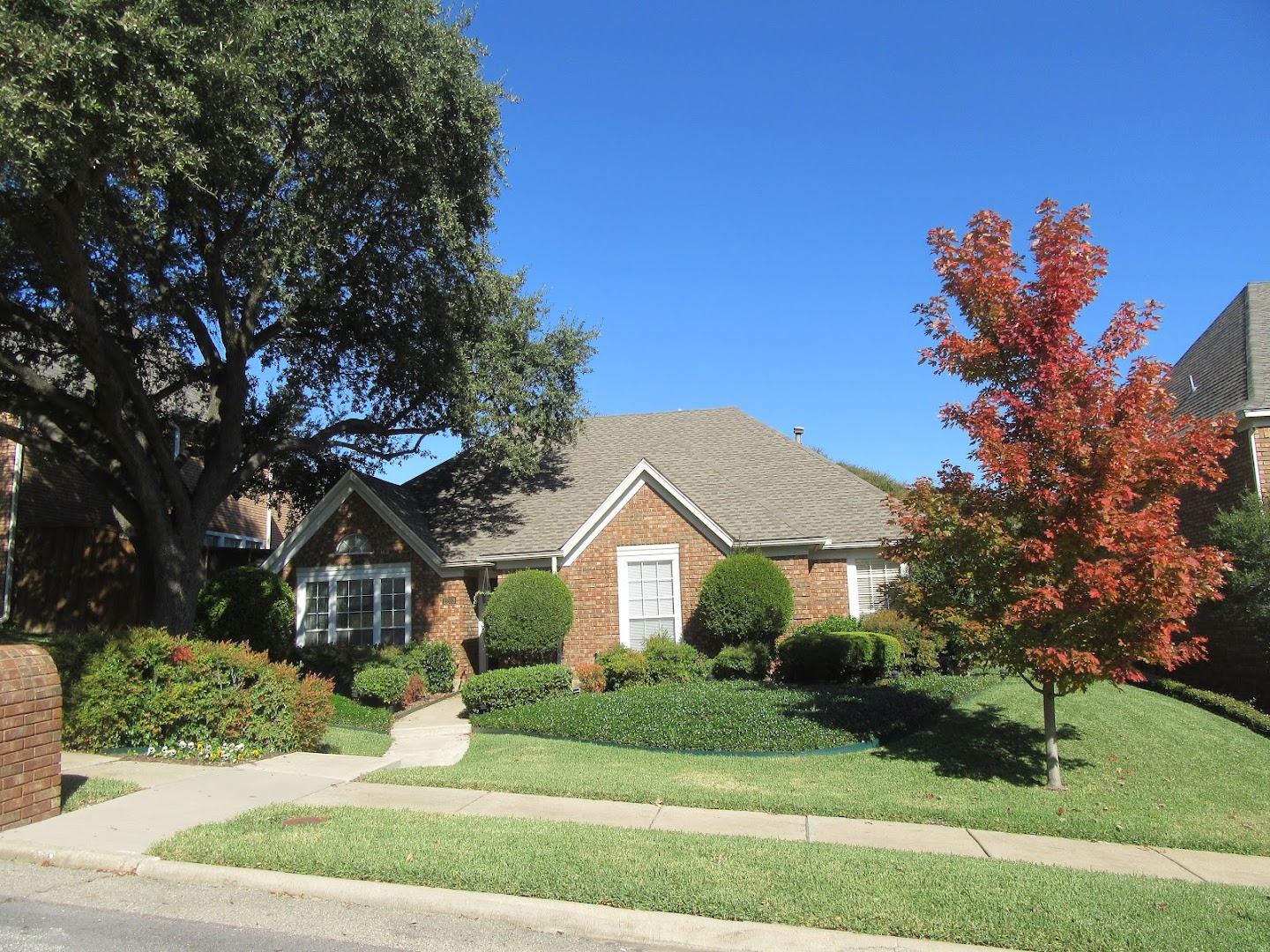 Brick home in Plano with a shingle roof by Eagle Roofing
