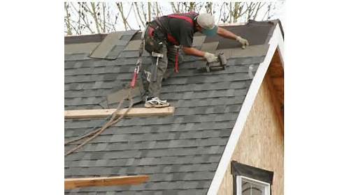Roofer installing new shingles on a home